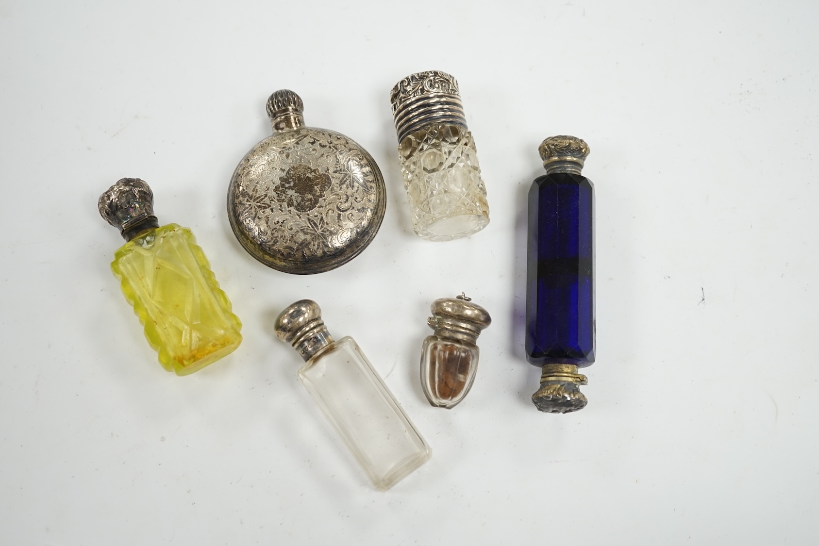 A George V engraved silver moon shaped scent bottle, James Dixon & Sons, Sheffield, 1912, together with five other white metal mounted glass scent bottles. Condition - poor to fair